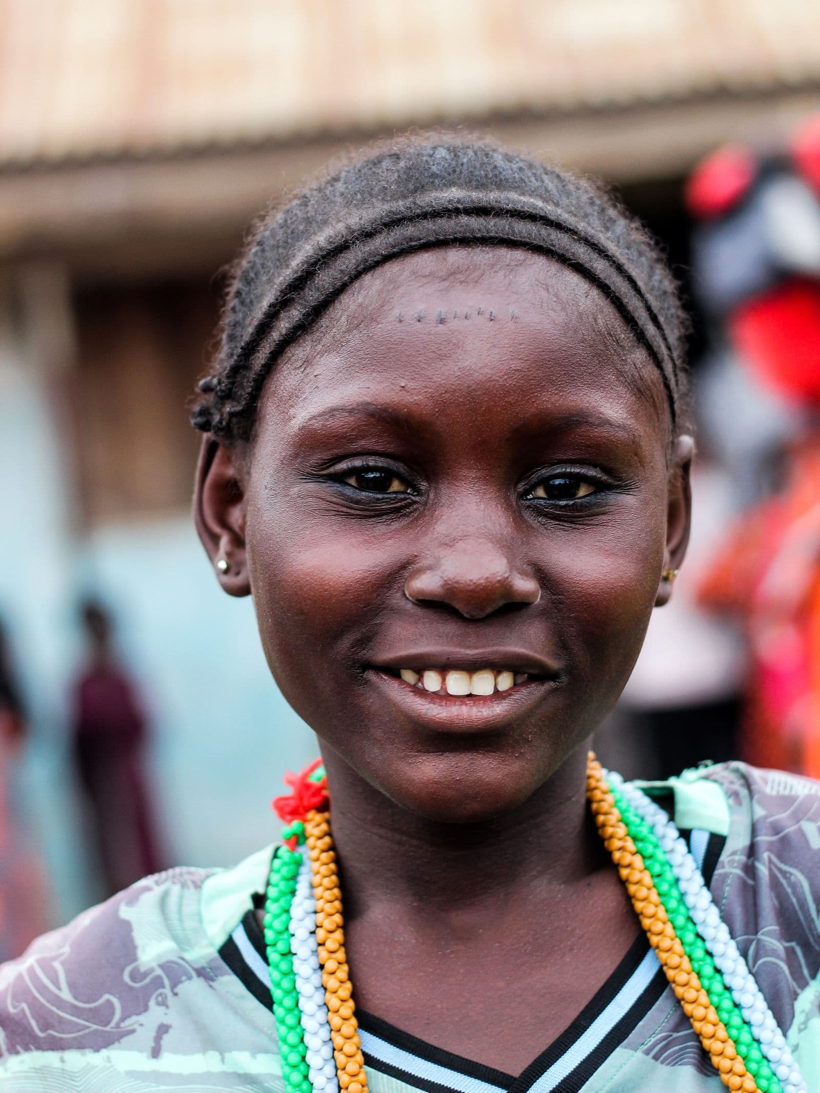 Young African girl with colorful beads, smiling brightly
